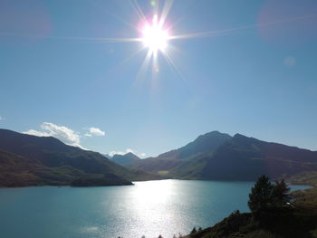 Scenic view of mountains against blue sky on sunny day