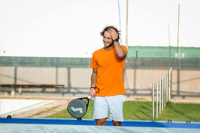 Man with tennis racket standing in court