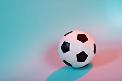 Close-up of soccer ball over colored background