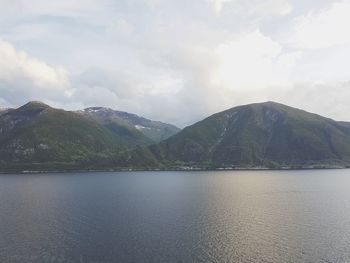 Scenic view of lake by mountains against sky