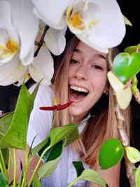 Portrait of happy woman with flower petals on plant