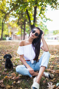 Young woman sitting on sunglasses