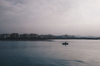 Scenic view of sea against sky in city