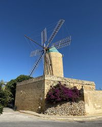 Low angle view of traditional windmill against blue sky