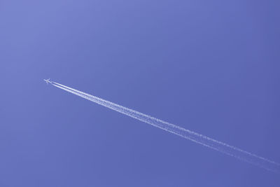 Low angle view of vapor trail against blue sky