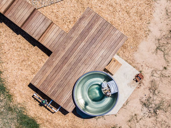 Drone view of a wood fired stainless steel outdoor jacuzzi and a wooden deck at a luxury hotel.