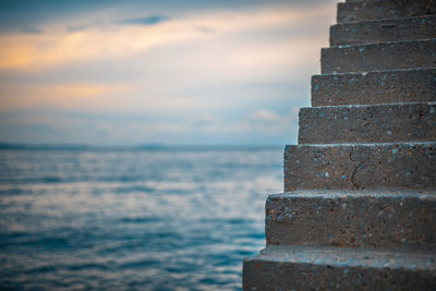 Close-up of wall by sea against sky