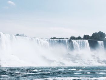 Scenic view of waterfall against sky