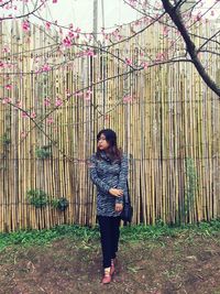 Full length of woman standing against trees