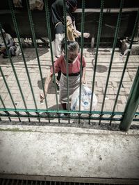 High angle view of boy standing on railing