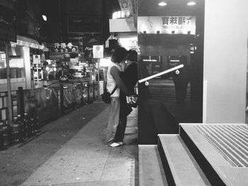 Rear view of man standing on street at night