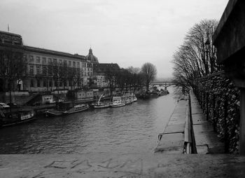 River amidst buildings in city against sky