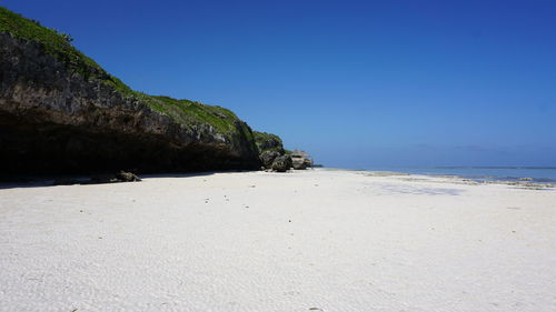 Scenic view of beach against clear blue sky