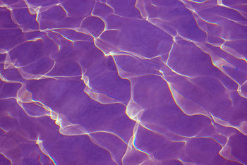 Pop art surreal purple colored water surface reflecting with sunlight for abstract background