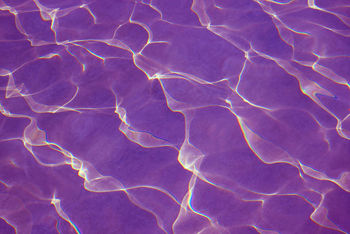Pop art surreal purple colored water surface reflecting with sunlight for abstract background