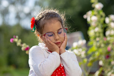 Portrait of a sad beautiful little girl in glasses