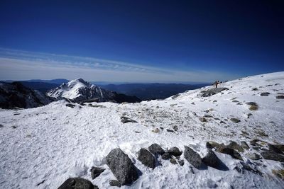 Scenic view of snowcapped mountains against blue sky