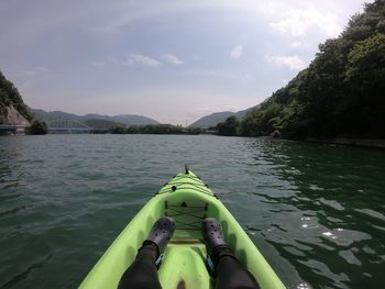 Low section of person in lake against sky