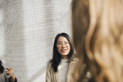 Smiling businesswoman listening to female coworker in meeting