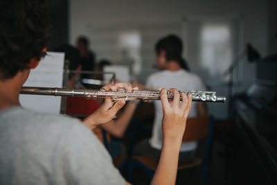 Rear view of man playing flute