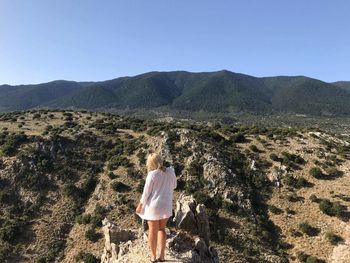 Rear view of woman walking on mountain road