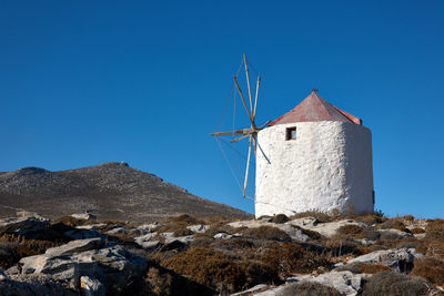 Low angle view of windmill against clear blue sky