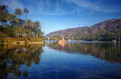 Scenic view of lake by trees against sky