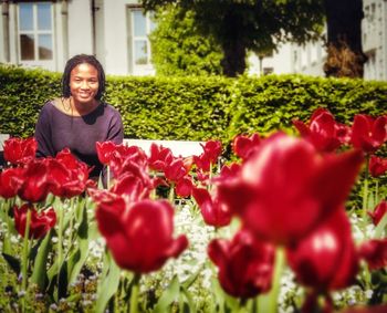 Portrait of smiling woman with red flowers