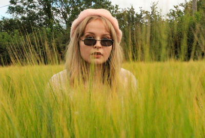 Portrait of young lady wearing sunglasses on field