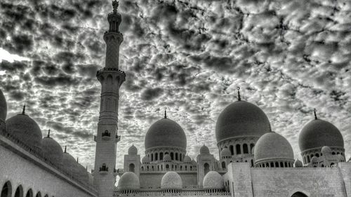 Low angle view of mosque against cloudy sky