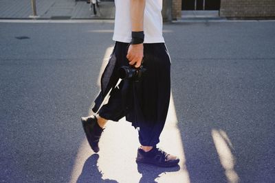 Low section of man walking on road