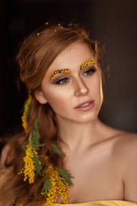 Portrait of a young woman in yellow mimosa flowers