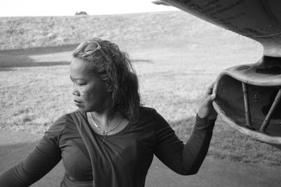 Woman looking away while standing on land