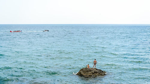 Scenic view of rocks in sea against clear sky