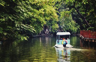 People in lake against trees