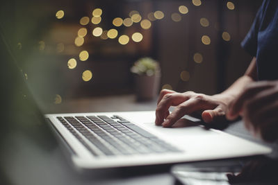 Midsection of man using laptop on table