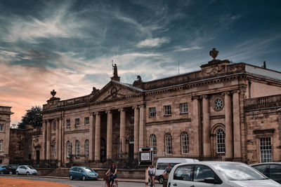 View of city street against cloudy sky
