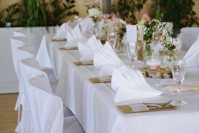 Flower vase and wineglasses on table in dining room