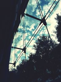 Low angle view of silhouette trees against blue sky