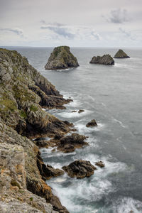 Scenic view of rocks in sea against sky