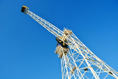 Low angle view of crane against blue sky