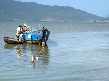 Men fishing in sea against mountains