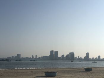 Sea and buildings against clear sky