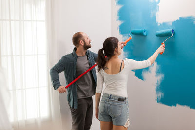 Young couple standing against wall