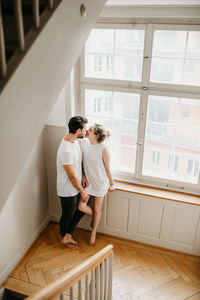 Couple standing against window