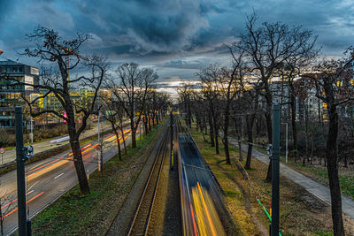 Railroad tracks by road against sky