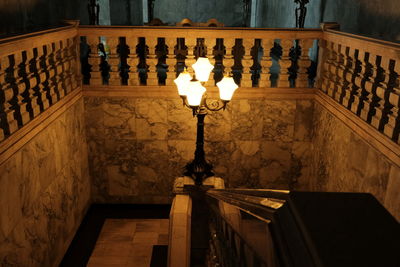 Low angle view of illuminated lamp on staircase by building