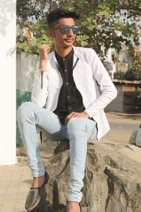 Portrait of young man wearing sunglasses standing outdoors