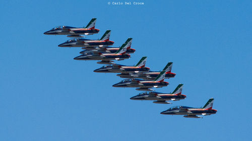 Low angle view of airplane flying against clear blue sky