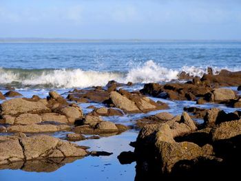 Scenic view of rocks on beach against sky